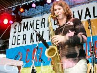 Musiker auf der Bühne vor Banner des Sommerfestes, Quelle: DTF