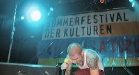 Sänger im weißen Tanktop vor Banner des Sommerfestes, Quelle: DTF