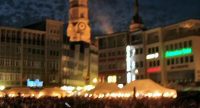 Marktplatz voller Menschen vor dunklem Nachthimmel, Quelle: DTF
