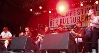 Band sitzt auf der Bühne vor Banner des Sommerfestes, Quelle: DTF