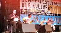Band sitzt auf der Bühne vor Banner des Sommerfestes, Quelle: DTF