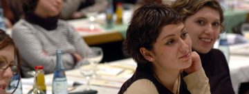 junge Frauen im Publikum schauen interessiert Richtung Podium