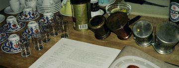 aufgeschlagenes Kochrezept für Plätzchen neben Kafeegläsern