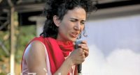 Frau mit rotem Schal singt mit geschlossenen Augen, Quelle: DTF