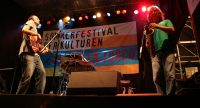 Band auf der Bühne vor Banner des Sommerfestivals, Quelle: DTF