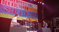 Band auf der Bühne vor Banner des Sommerfestivals, Quelle: DTF