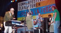 Band auf der Bühne vor Banner des Sommerfestivals, Quelle: DTF