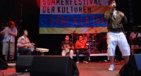 Band auf der Bühne vor Banner des Sommerfestivals, Quelle: DTF