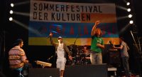Band auf der Bühne vor Banner des Sommerfestivals, Quelle: DTF