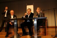 Diskussionsteilnehmer*innen sitzend an einem Holztisch auf dem Podium, Quelle: DTF