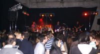 Band auf rot beleuchteter Bühne vor Publikum, Quelle: DTF