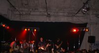 Band auf rot beleuchteter Bühne vor Publikum, Quelle: DTF