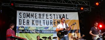 X-Tanbul auf der Bühne vor Banner des Sommerfestivals