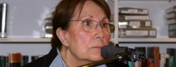 Frau im schwarzen Sakko schaut Richtung Publikum