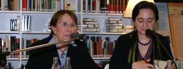 zwei sitzende Frauen am Podium vor einem Bücherregal