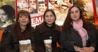drei Frauen vor Wand mit FIlmpostern halten Popcornbecher in den Händen, Quelle: DTF