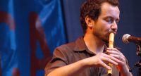 Mann spielt Flöte mit geschlossenen Augen, Quelle: DTF