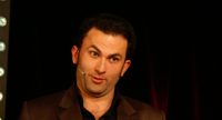 Fatih Cevikkollu gestikulierend auf der Bühne, Quelle: DTF
