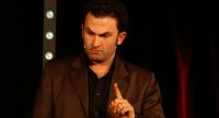 Fatih Cevikkollu gestikulierend auf der Bühne, Quelle: DTF
