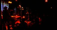 Sänger und Band auf der Bühne vor Silhouette des Publikums, Quelle: DTF