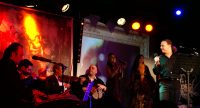 Sänger schaut lächelnd zurück zu seiner Band, Quelle: DTF