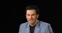 Fatih Cevikkollu gestikulierend auf der Bühne, Quelle: DTF