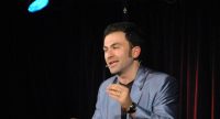 Fatih Cevikkollu gestikulierend auf der Bühne, Quelle: DTF