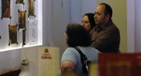 Familie steht vor Wand mit Fotos, Quelle: DTF