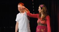 Serhat Dogan und Frau im pinken Oberteil heben die Hand zum Publikum, Quelle: DTF