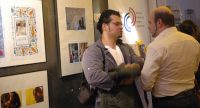 zwei Männer unterhalten sich vor Wand mit Fotos, Quelle: DTF