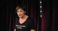 Frau im schwarzen T-Shirt gestikulierend auf der Bühne, Quelle: DTF