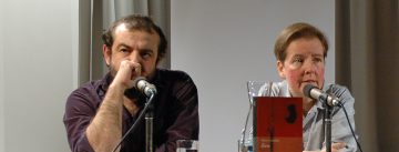 Murat Uyurkulak und Sabine Adatepe sitzen nebeneinander vor Banner des DTF