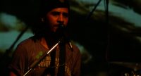 Bassist auf grün beleuchteter Bühne, Quelle: DTF