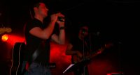 Sänger/Gitarrist neben Bassist auf rot beleuchteter Bühne, Quelle: DTF