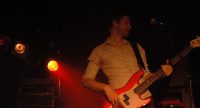Bassist auf rot beleuchteter Bühne, Quelle: DTF
