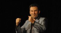 Fatih Çevikkollu spricht gestikulierend vor Silhouette des Publikums, Quelle: DTF