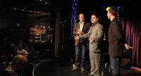drei Männer stehen sprechend auf der Bühne, Quelle: DTF