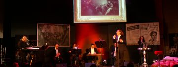 Mario Rispo und Band auf der Bühne vor SIlhouette des Publikums
