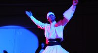 tanzender Derwisch auf blau beleuchteter Bühne, Quelle: DTF
