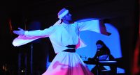 tanzender Derwisch auf blau beleuchteter Bühne, Quelle: DTF