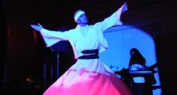 tanzender Derwisch auf blau beleuchteter Bühne, Quelle: DTF
