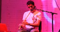 sitzender Mann spielt Nay auf violett beleuchteter Bühne, Quelle: DTF
