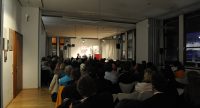 Diskussionteilnehmer*innen vor Silhouette des Publikums, Quelle: DTF