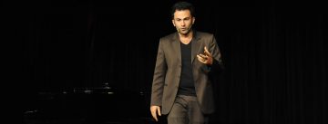 Fatih Çevikkollu geht gestikulierend über die Bühne