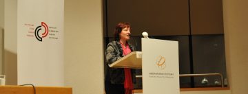 Frau am Rednerpult vor Banner des DTF