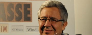 Zülfü Livaneli lächelt in Richtung der Kamera