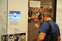 Mann mit Kopfhörer um den Kopf steht vor Ausstellungswand, Quelle: DTF