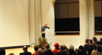 sitzende Menschen schauen auf Mann am Rednerpult, Quelle: DTF