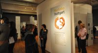 Menschen im Ausstellungsraum schauen sich ausgestellte Wände mit Text und Bilder an, Quelle: DTF