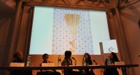 Diskussionsteilnehmer*innen sitzend am Holztisch auf dem Podium, Quelle: DTF